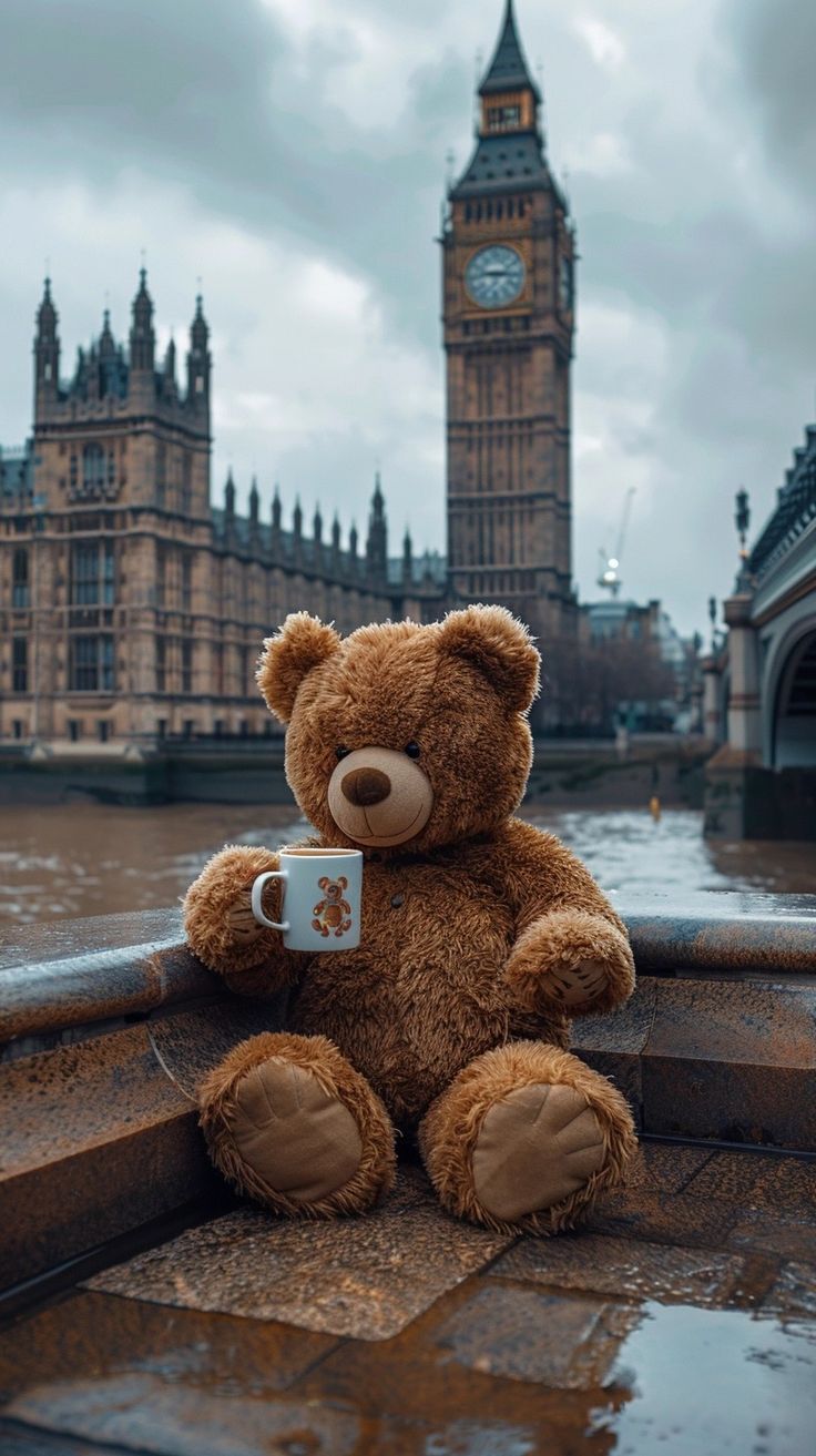 a brown teddy bear sitting on the edge of a boat with big ben in the background