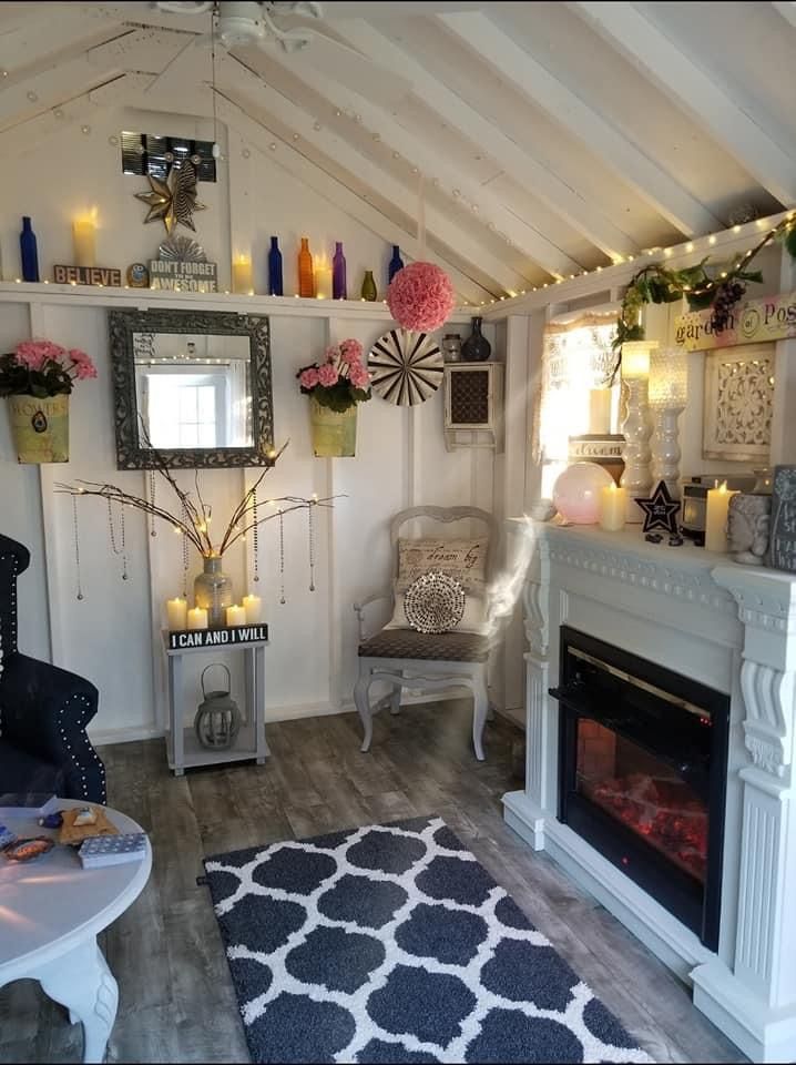 a living room filled with furniture and a fire place under a roof covered in lights