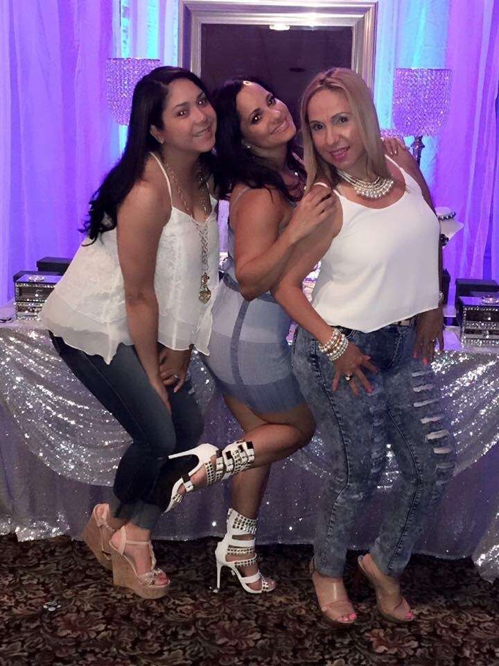 three women posing for the camera in front of a table with silver sequins