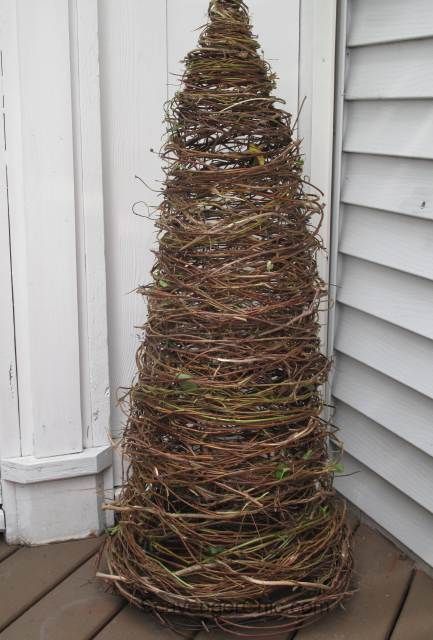 a christmas tree made out of twigs on the porch