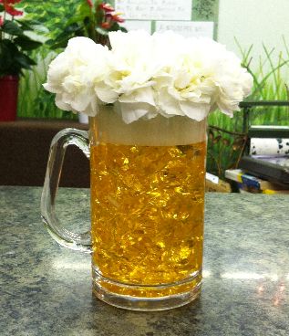 a glass mug filled with white flowers on top of a table