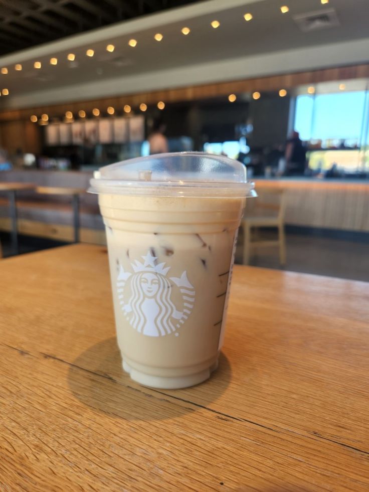 a starbucks drink sitting on top of a wooden table