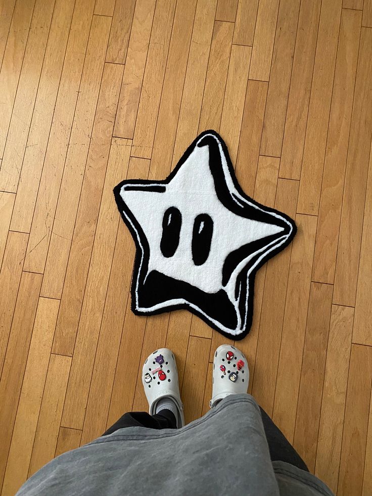 a person standing in front of a rug with a star on the floor next to it