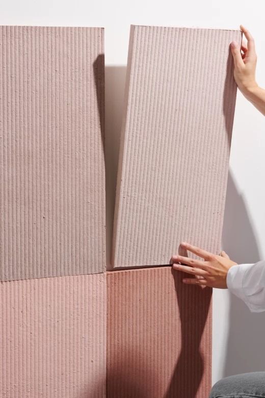 a woman is sitting on the floor with her hands on some cardboard