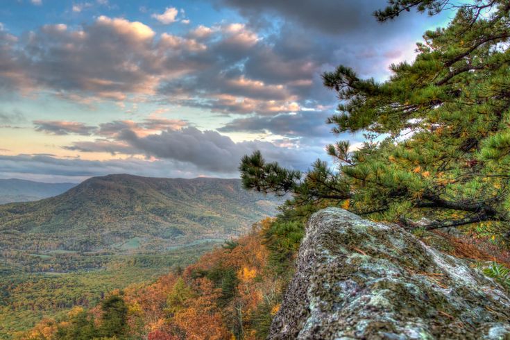 a scenic view of the mountains and trees from a high point on a mountaintop