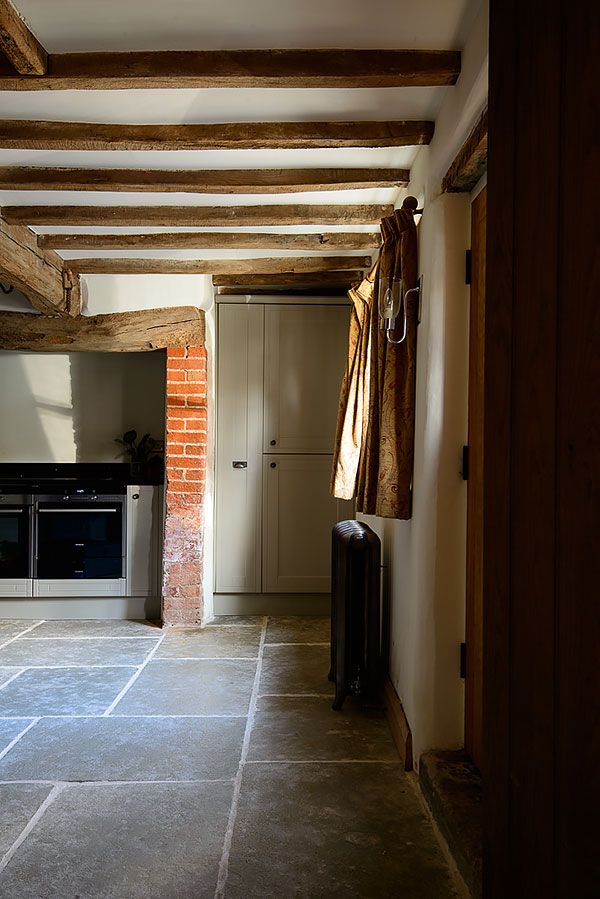 an empty kitchen with brick walls and exposed beams