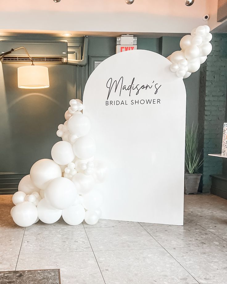 a white balloon arch with the words madison's bridal shower written on it