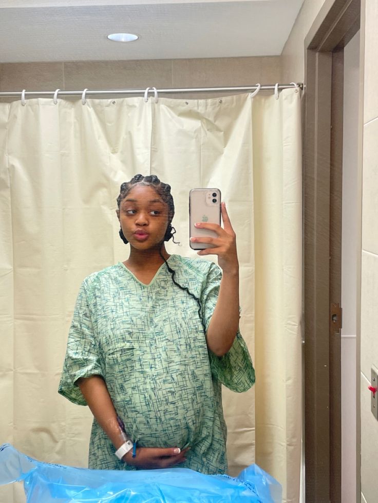 a woman taking a selfie in front of a shower curtain with her cell phone