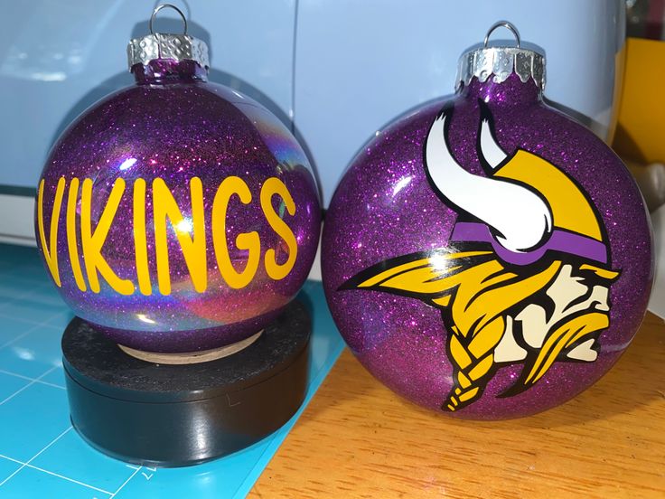 two minnesota ornament sitting on top of a wooden table next to each other