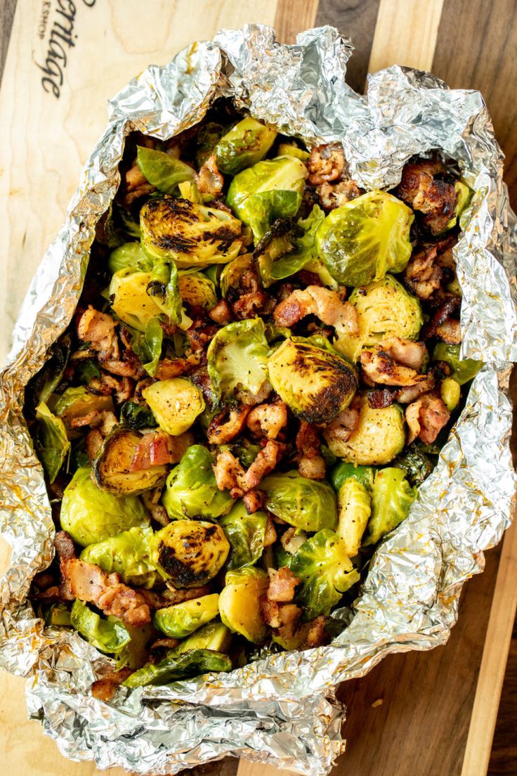 brussel sprouts and bacon in foil on a cutting board