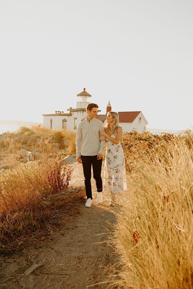 a man and woman walking down a dirt road