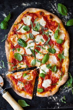 a pizza sitting on top of a pan covered in cheese and veggies next to a spatula