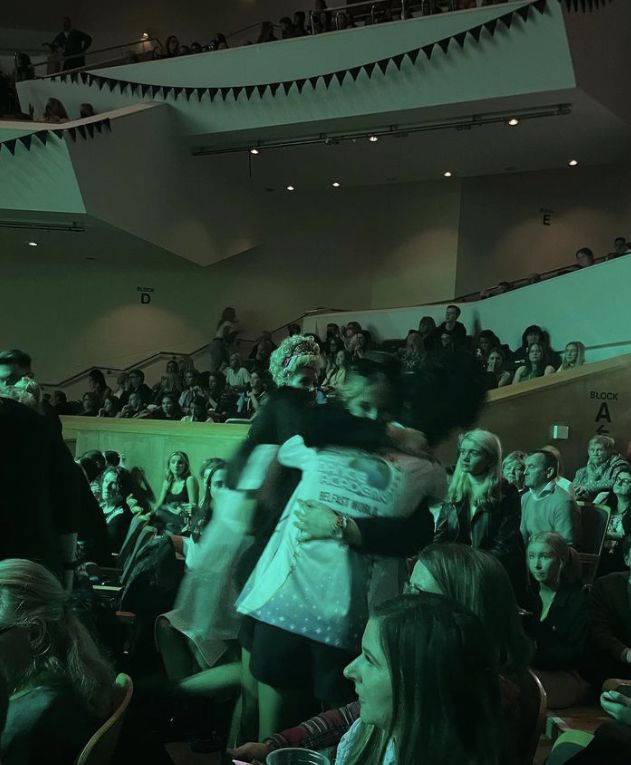 two people hugging each other in front of an audience