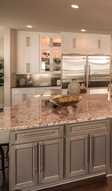 a large kitchen with marble counter tops and stainless steel appliances