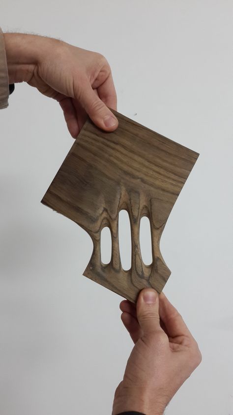 two hands are holding a piece of wood