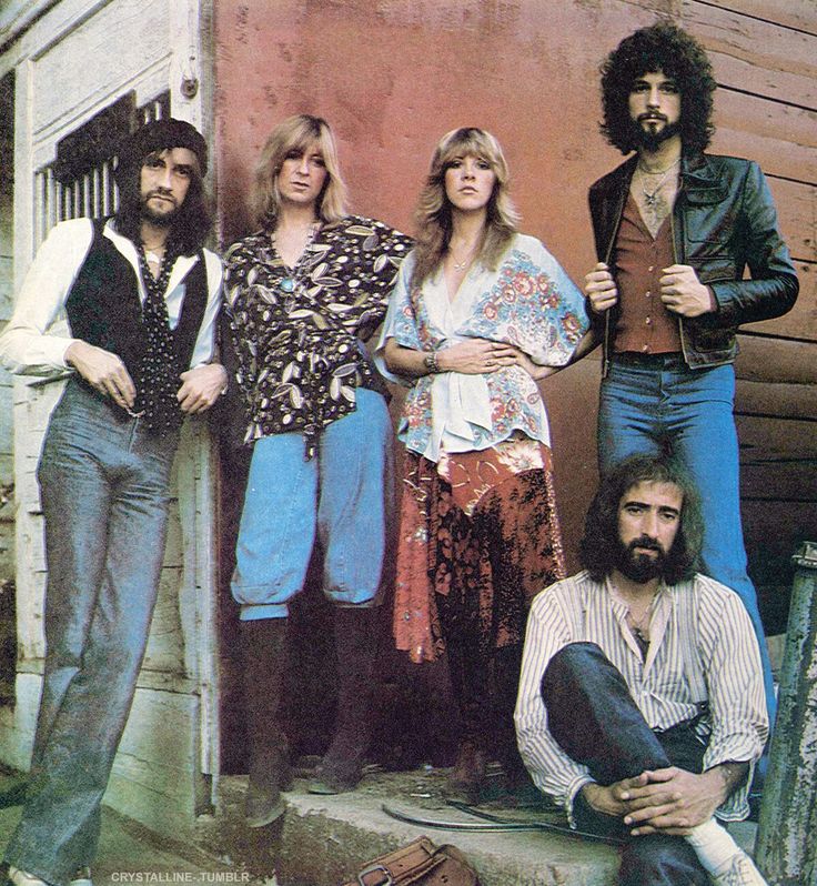 the bee gees posing for a photo in front of a building