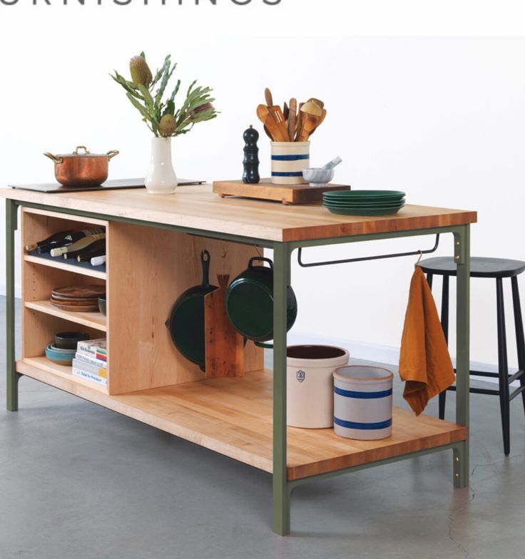 a kitchen island with pots, pans and utensils sitting on top of it