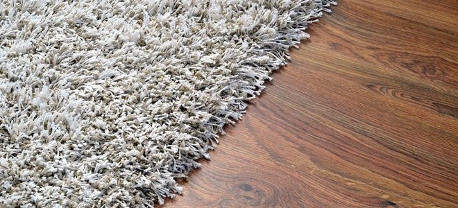 an area rug is laying on the floor with wood floors and hard wood planks