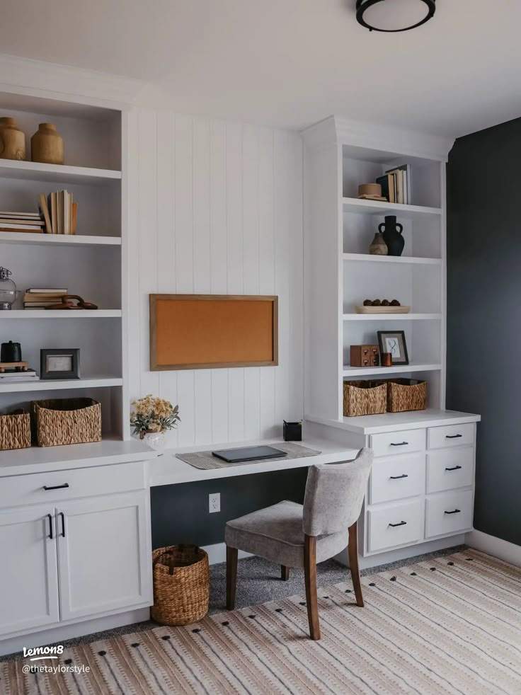 a home office with built - in bookshelves and white cabinets