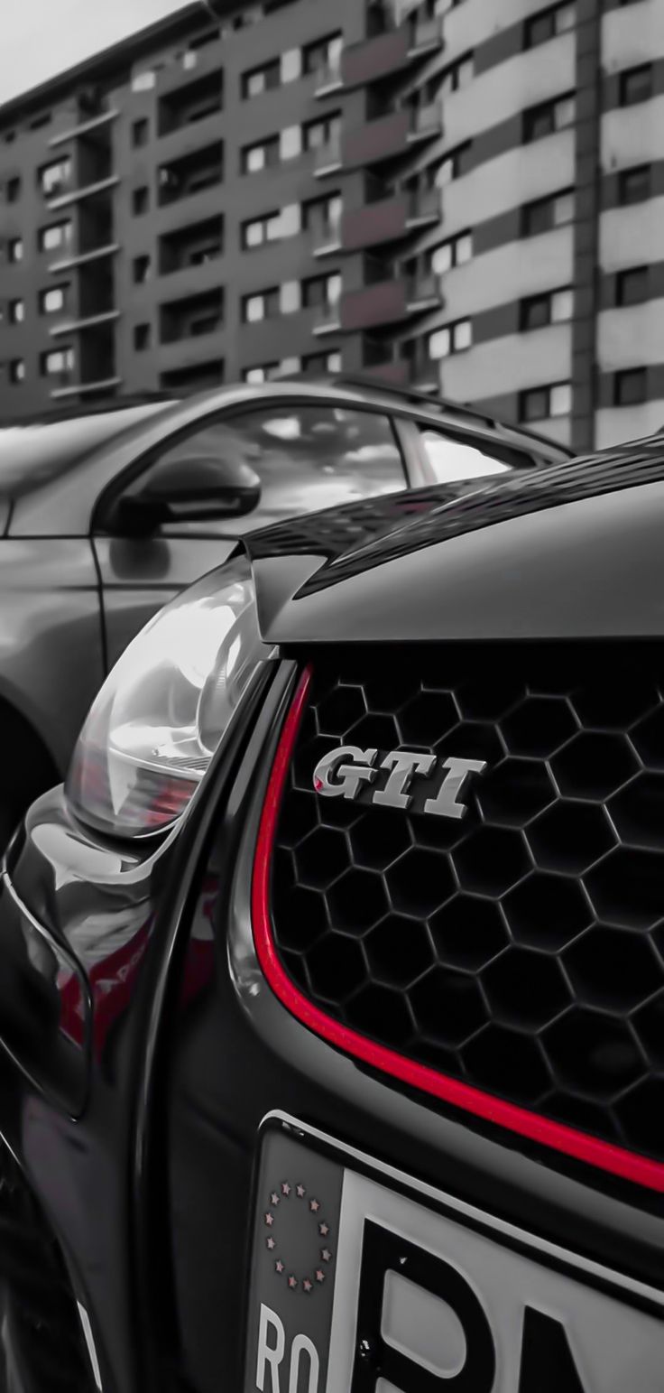 two cars parked next to each other in front of tall buildings