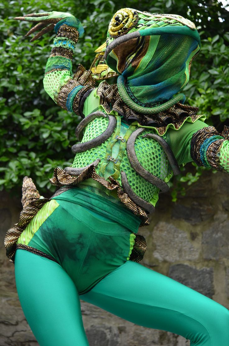 a woman dressed in green is dancing outside