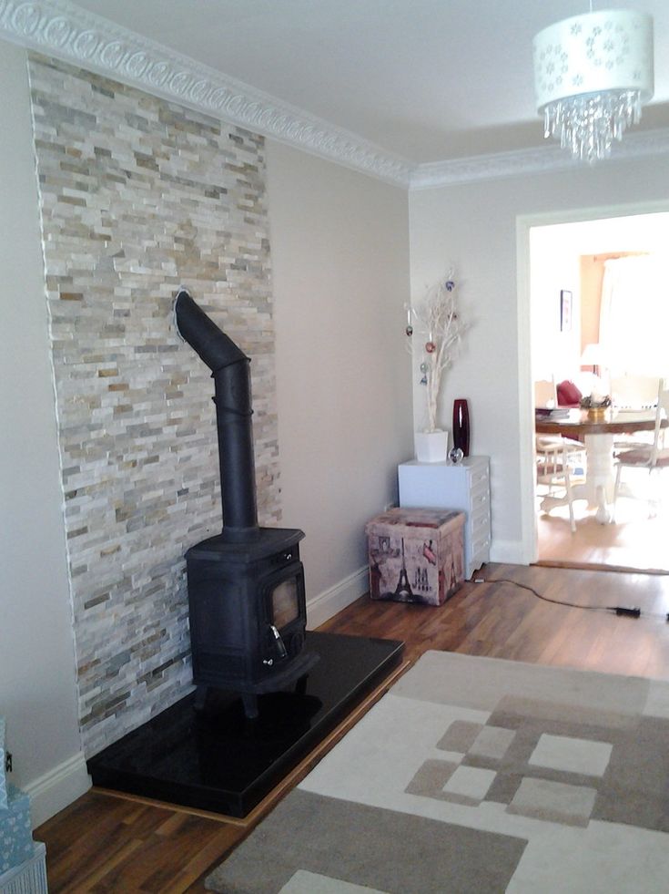 a living room with a wood burning stove in the center and a rug on the floor