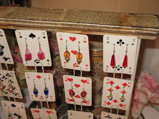 a set of playing cards with earrings hanging from them