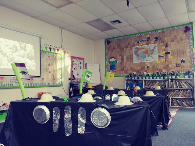 a classroom with several tables covered in black cloths and hats on top of them