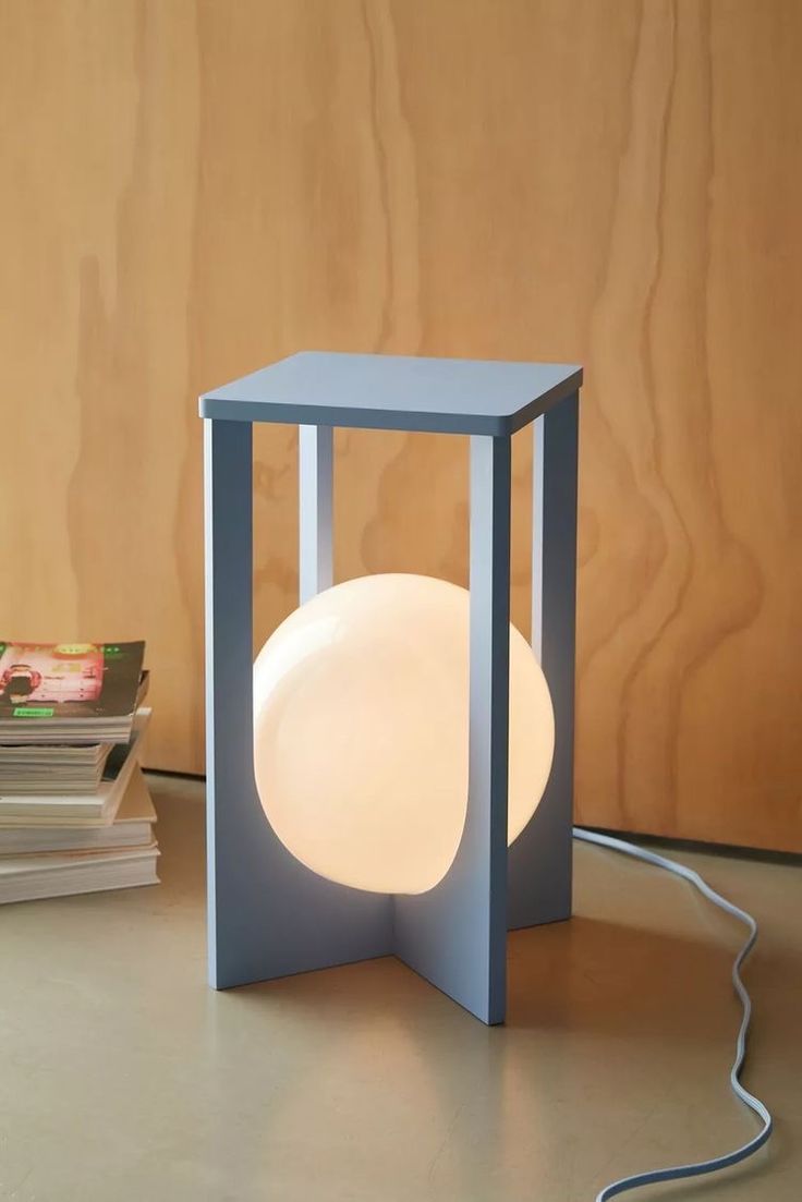 a lamp sitting on top of a table next to books