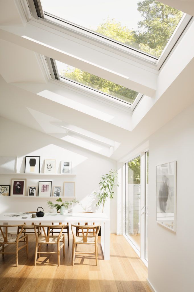 a dining room with skylights and wooden floors