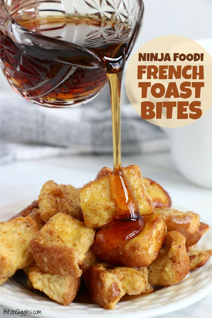 french toast bites being drizzled with syrup from a glass bottle on a white plate