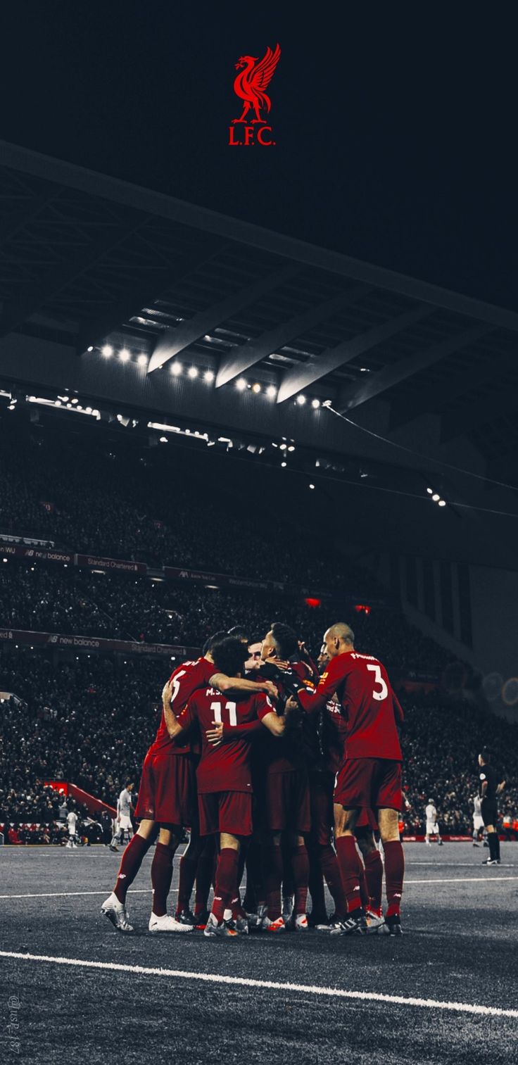 a group of soccer players huddle together on the field