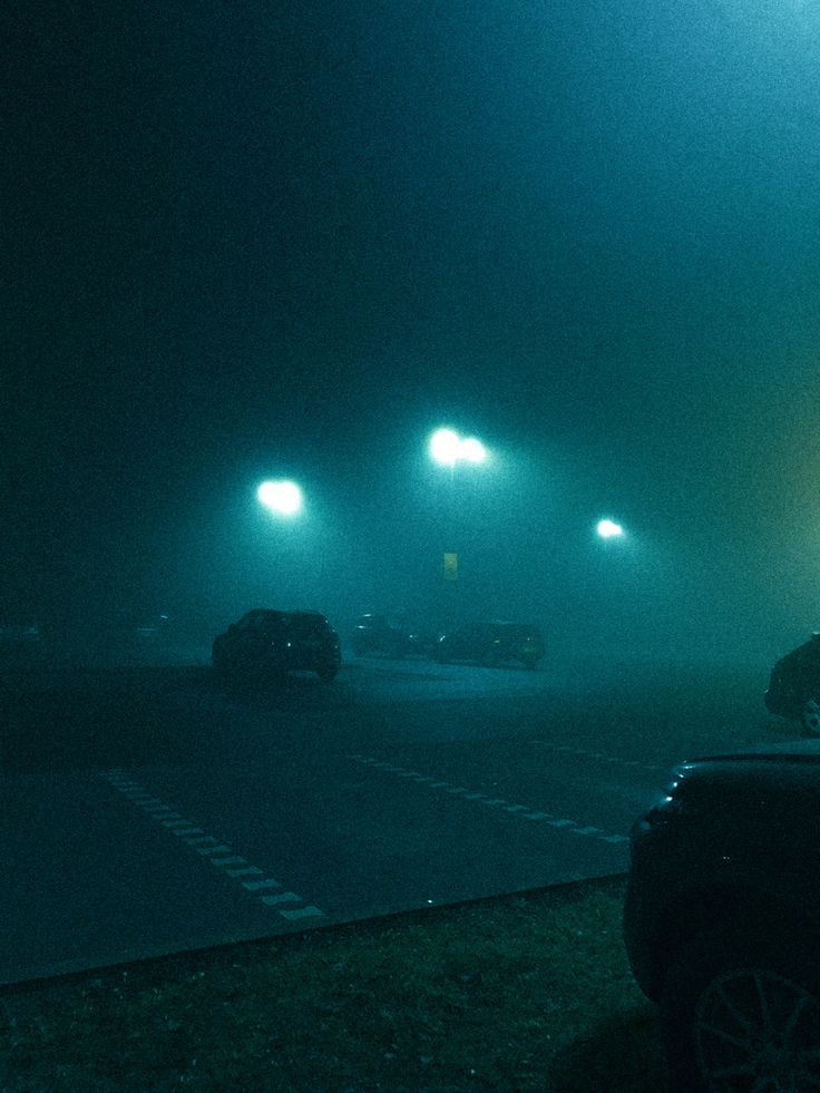 cars driving on a foggy road at night