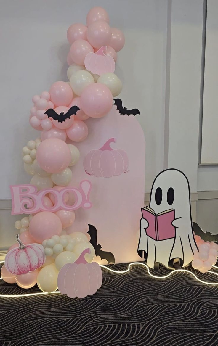 balloons and decorations are on display at a halloween themed birthday party in the shape of a ghost