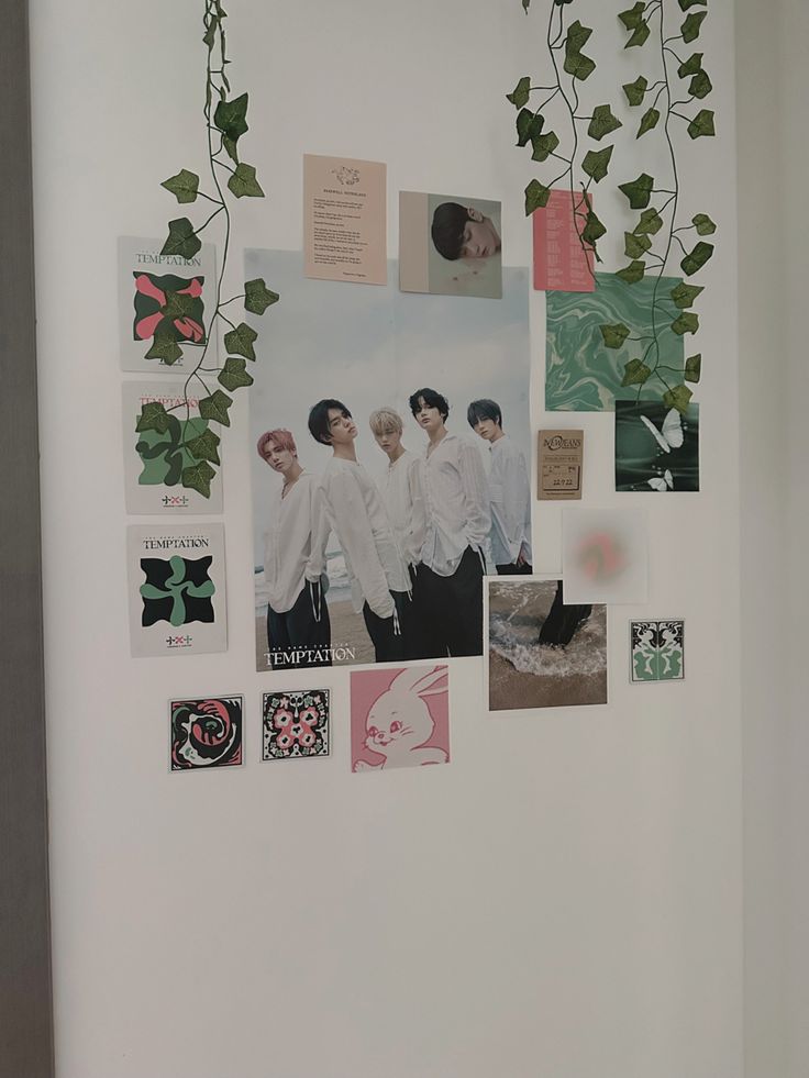 a white wall covered in photos and magnets with ivy growing on the side of it