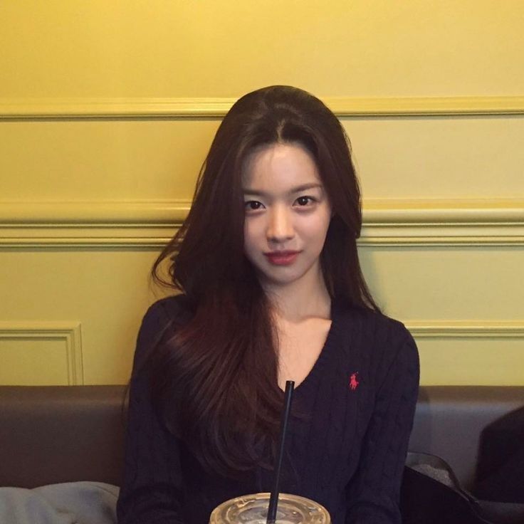 a woman sitting on a couch with a drink in front of her and a straw