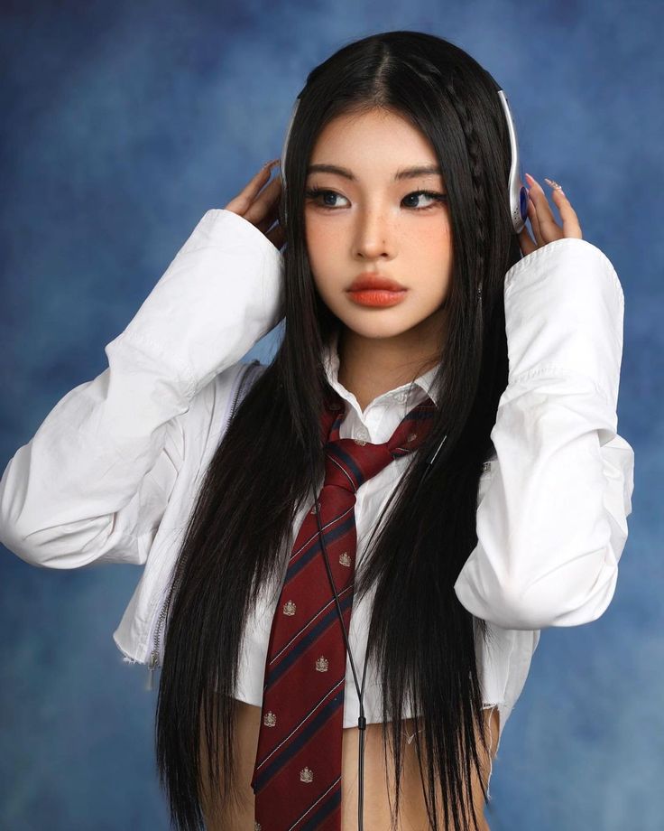 a woman with long black hair wearing a tie and white shirt is posing for a photo