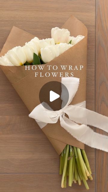 a bouquet of white roses wrapped in brown paper with the words how to wrap flowers