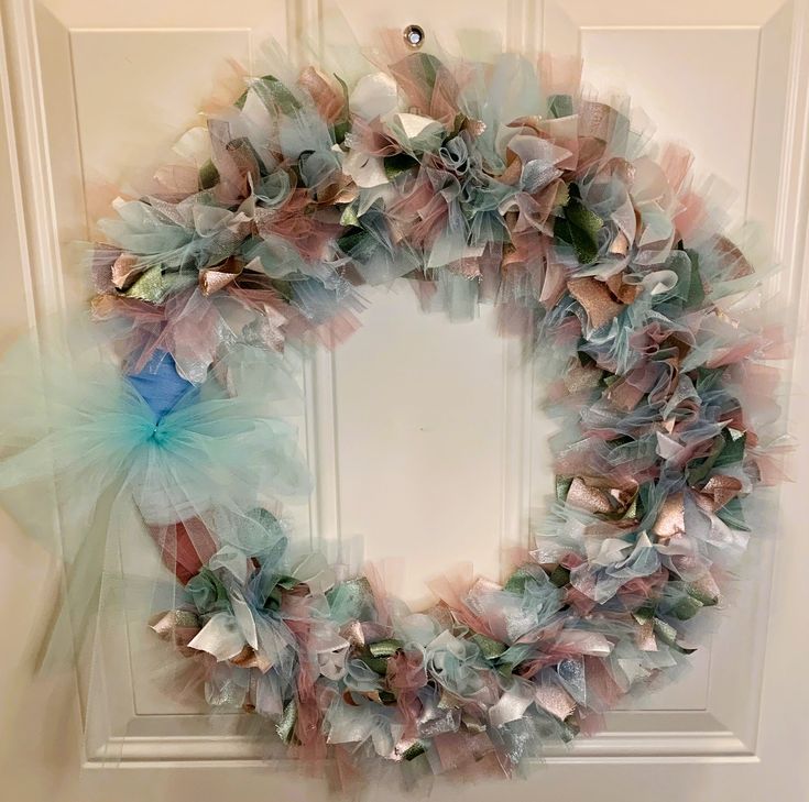 a wreath made out of tulle and bows hangs on the front door's wall