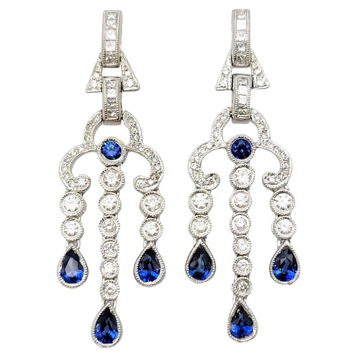 Discover the epitome of elegance with these captivating chandelier dangle earrings, exquisitely crafted in 14 karat white gold. A testament to timeless beauty, these earrings boast a delightful combination of natural sapphires and diamonds, sure to leave a lasting impression. The natural sapphires take center stage, with a total carat weight of 1.12. The sapphires feature a mix of pear and round cuts, expertly faceted to enhance their deep blue hue. The vibrant color of the sapphires adds a touch of sophistication and allure to these earrings, making them a standout piece in any collection. Complementing the sapphires are sparkling natural diamonds, totaling 0.95 carats. The diamonds showcase a brilliant mix of round and princess cuts, allowing them to catch the light from every angle. Wit Diamond Chandelier, Sapphire Color, Gold Chandelier, Princess Diamond, Natural Sapphire, Center Stage, Sapphire Diamond, Diamond Clarity, Chandelier Earrings