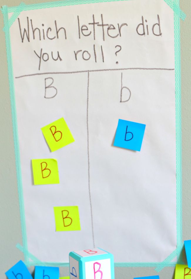 a sign that says which letter did you roll? and blocks with letters on them