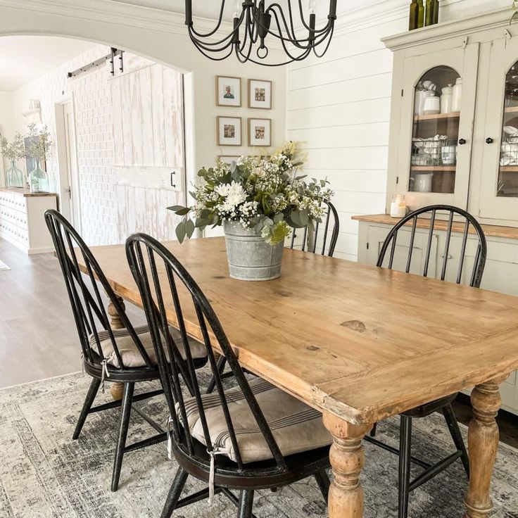 a dining room table with chairs and a potted plant