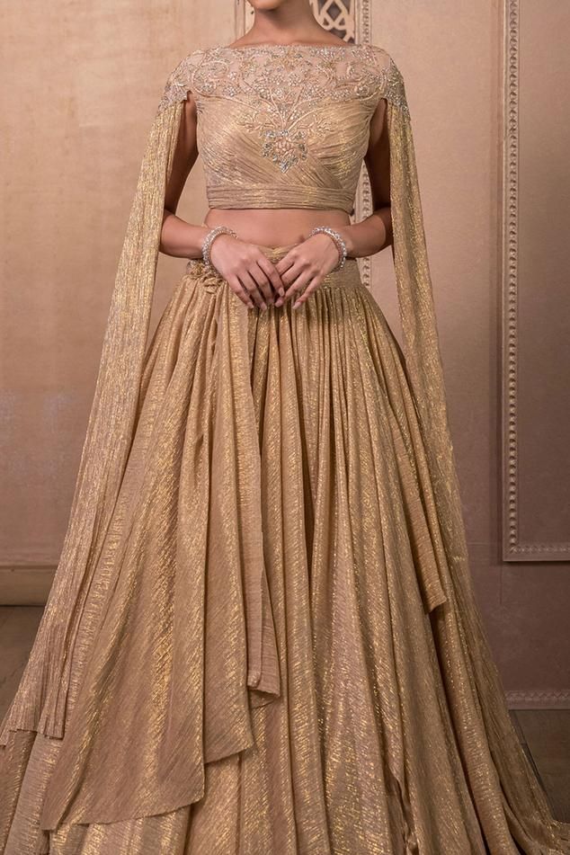 Gold lehenga set featuring a floral embroidered blouse with draped sleeves. The layered skirt is made of crinkle tulle and has a sheer back detail., Fit: Relaxed Tarun Tahiliani Lehenga, Skirt With Blouse, Cascade Skirt, Tulle Wings, Gold Drapes, Sangeet Outfit, Crystal Embroidery, Gold Blouse, Metallic Skirt