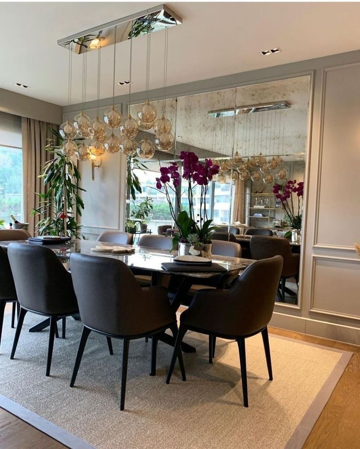 the dining room table is surrounded by black chairs and modern chandelier hanging from the ceiling