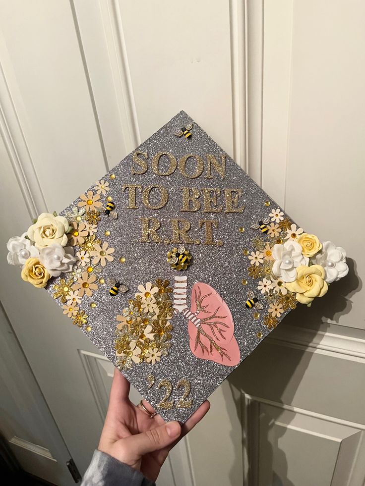 someone holding up a decorated graduation cap that says soon to bee rtt on it