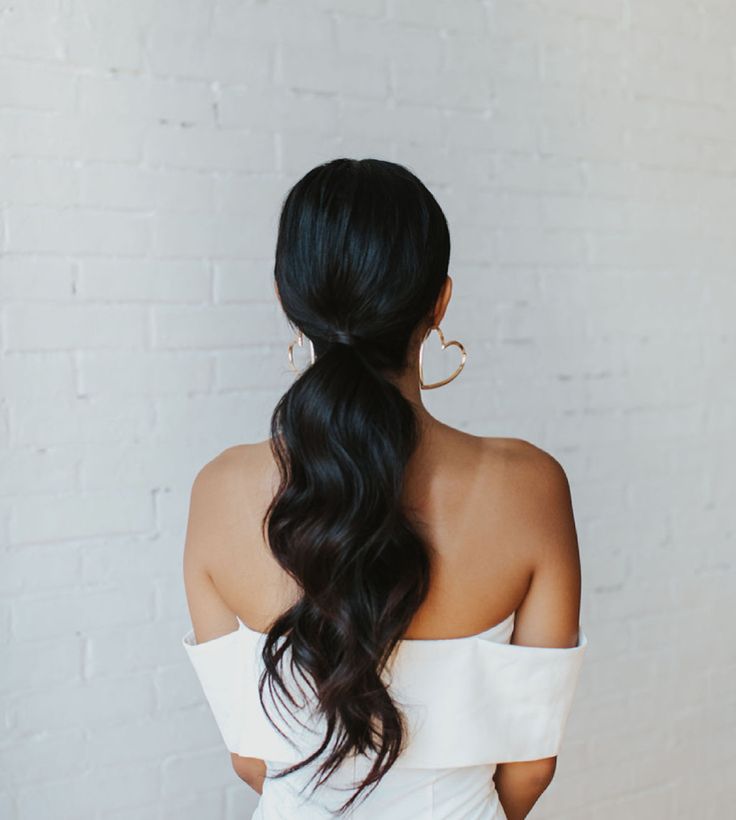 Low ponytail with loose waves Low Pony With Front Pieces, Dark Hair Down Wedding Styles, Low Ponytail With Two Bangs, Bridal Low Ponytail Hairstyles, Low Pony With Headband, Wedding Reception Ponytail, Low Pony With Curls, Bridal Ponytail Dark Hair, Clean Bridesmaid Hair