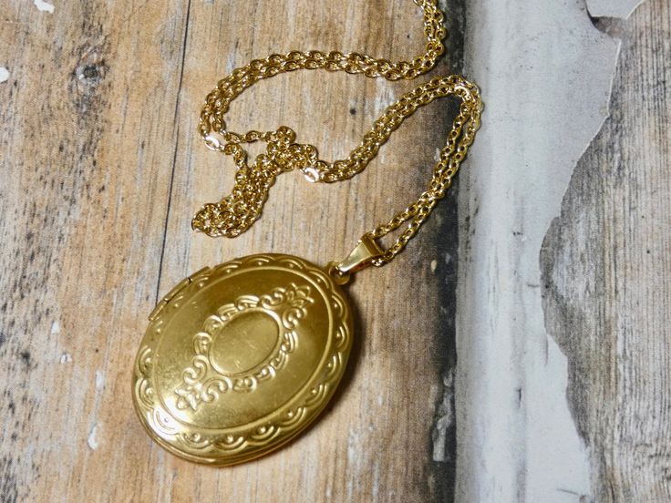 This gold oval locket necklace is a great keepsake necklace. It opens for your favorite two photographs. You will need to find a photo that fits and glue it into place. We do not place the photo in for you and at this time we do not engrave. It's the perfect gift for all ages. These lockets are not vintage, they are new. Unfortunalty it is very difficult to find vintage lockets. I T E M • DETAIL: - PENDANT SIZE: Outside measurements 7/8" x 1 1/4", Inside measurement 5/8 x 7/8 - CHAIN LENGTH: 16" Gold Oval Locket Necklace As A Gift, Gold Oval Pendant Locket Necklace Gift, Oval Pendant Locket Necklace For Keepsake, Vintage Charm Oval Locket Necklace Keepsake, Keepsake Locket Necklace With Vintage Charm And Oval Pendant, Oval Locket Necklace With Vintage Charm For Keepsake, Gold Oval Pendant Locket Necklace For Keepsake, Gold Oval Pendant Locket Necklace, Antique Gold Oval Locket Necklace For Gift