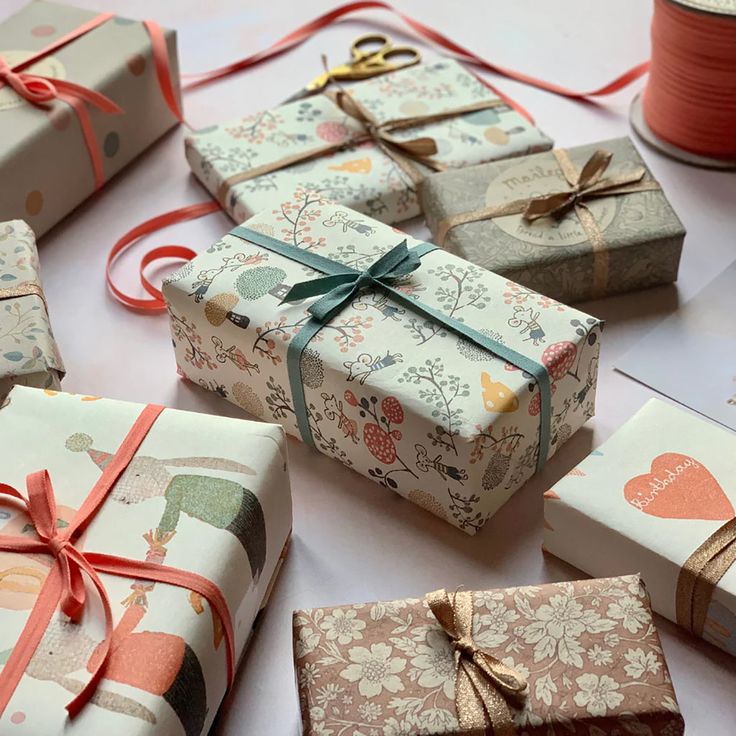 several wrapped presents sitting on top of a table next to spools of thread