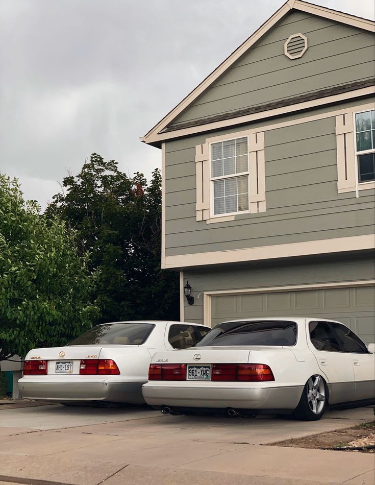 two cars parked in front of a house