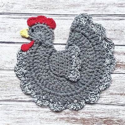 a crocheted chicken is shown on a wooden surface